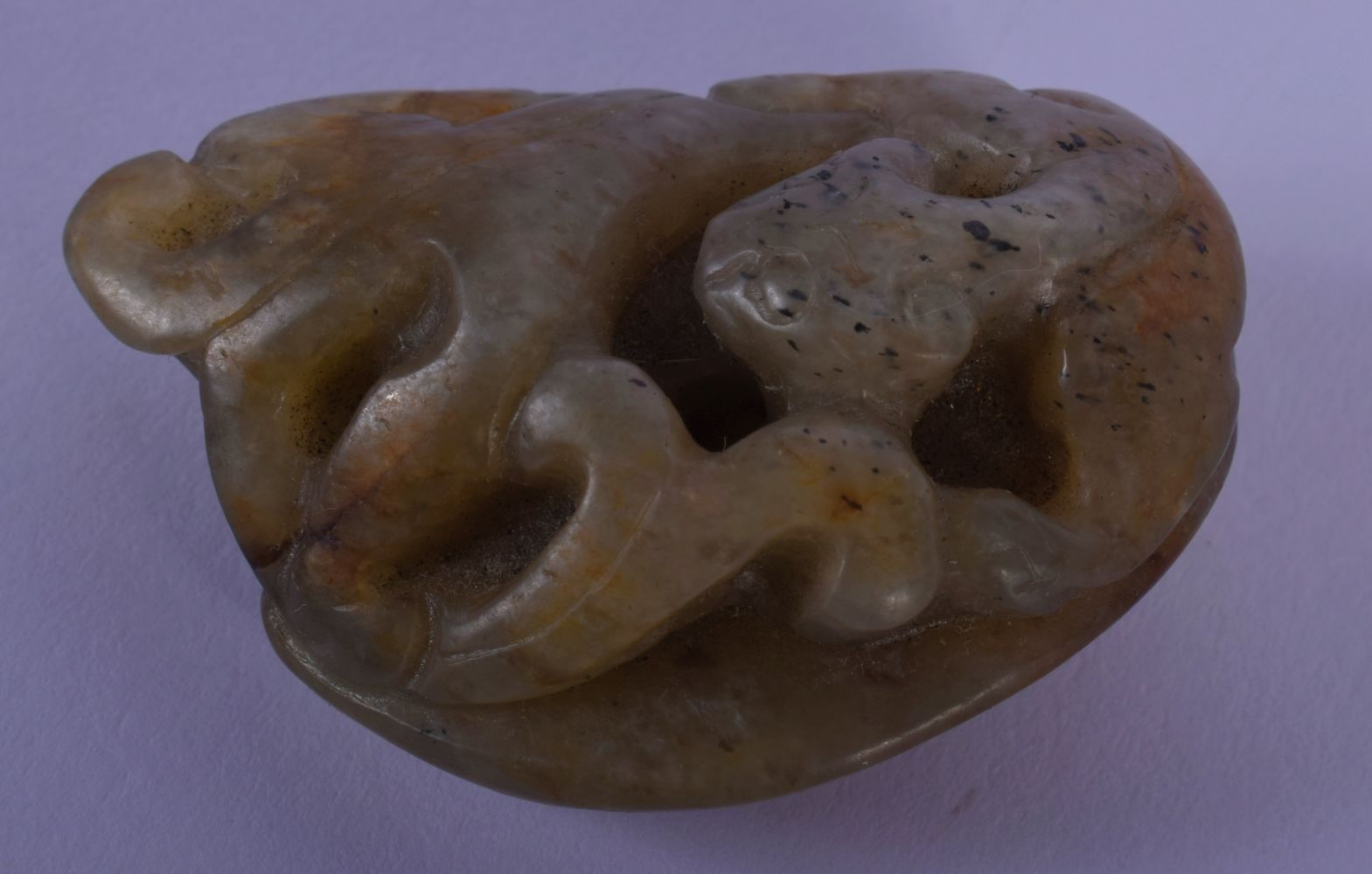 A SMALL 19TH CENTURY CHINESE CARVED JADE TOGGLE Qing, overlaid with a beast. 4 cm x 2.5 cm.