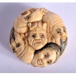 A JAPANESE BONE NETSUKE CARVED WITH FACES. 3.7cm diameter, 1.8cm wide, weight 25.6g