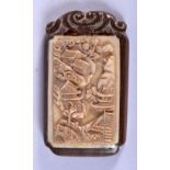 A CHINESE BONE AND WOOD PENDANT CARVED WITH A VILLAGE SCENE. 7.1cm x 4.1cm, weight 26g