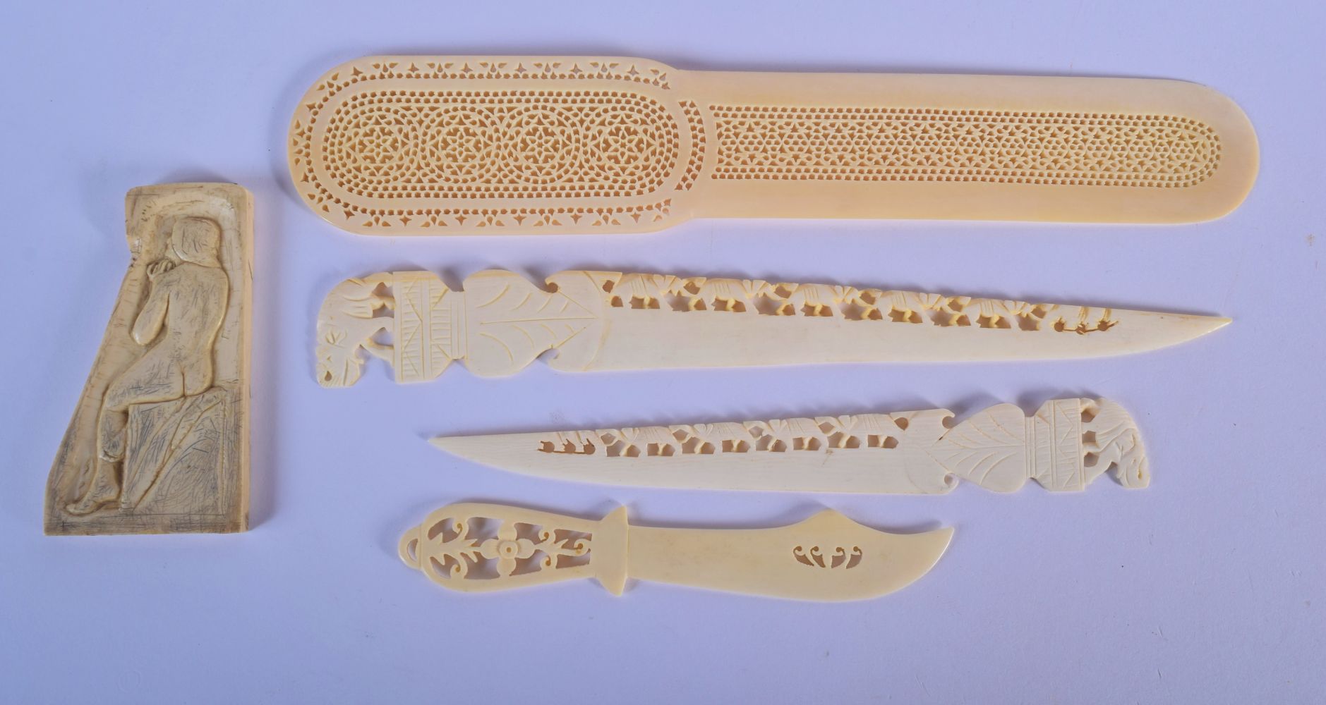A 19TH CENTURY ANGLO INDIAN CARVED IVORY LETTER OPENER together with similar wares. Largest 24 cm lo
