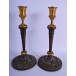 A PAIR OF 19TH CENTURY FRENCH TWO TONE BRONZE CANDLESTICKS mounted in acanthus. 28 cm high.