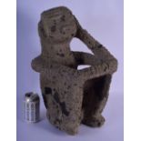 A LARGE SOUTH AMERICAN VOLCANIC STONE FIGURE OF A SEATED MALE possibly Peruvian, modelled clutching