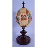 A RARE ANTIQUE AUSTRALIAN PAINTED OSTRICH EGG upon a mahogany plinth. 30 cm high.