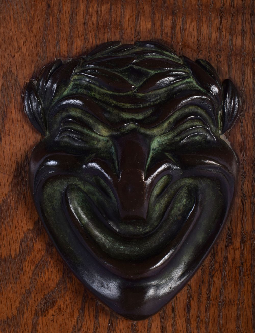 A CHARMING ARTS AND CRAFTS BRONZE MOUNTED OAK WALL PLINTH formed with a theatrical mask head. 40 cm - Image 2 of 3