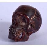 A JAPANESE CARVED BONE NETSUKE IN THE FORM OF A SKULL. 4cm x 2.9cm, weight 21.4g