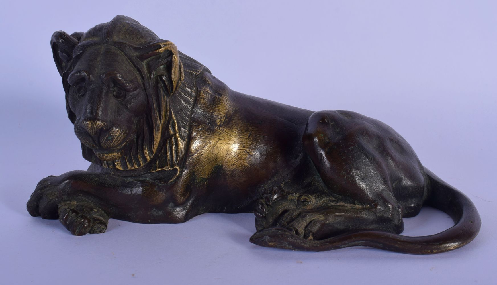 A 17TH/18TH CENTURY EUROPEAN BRONZE FIGURE OF A RECLINING LION modelled looking solemn. 18 cm x 9 cm