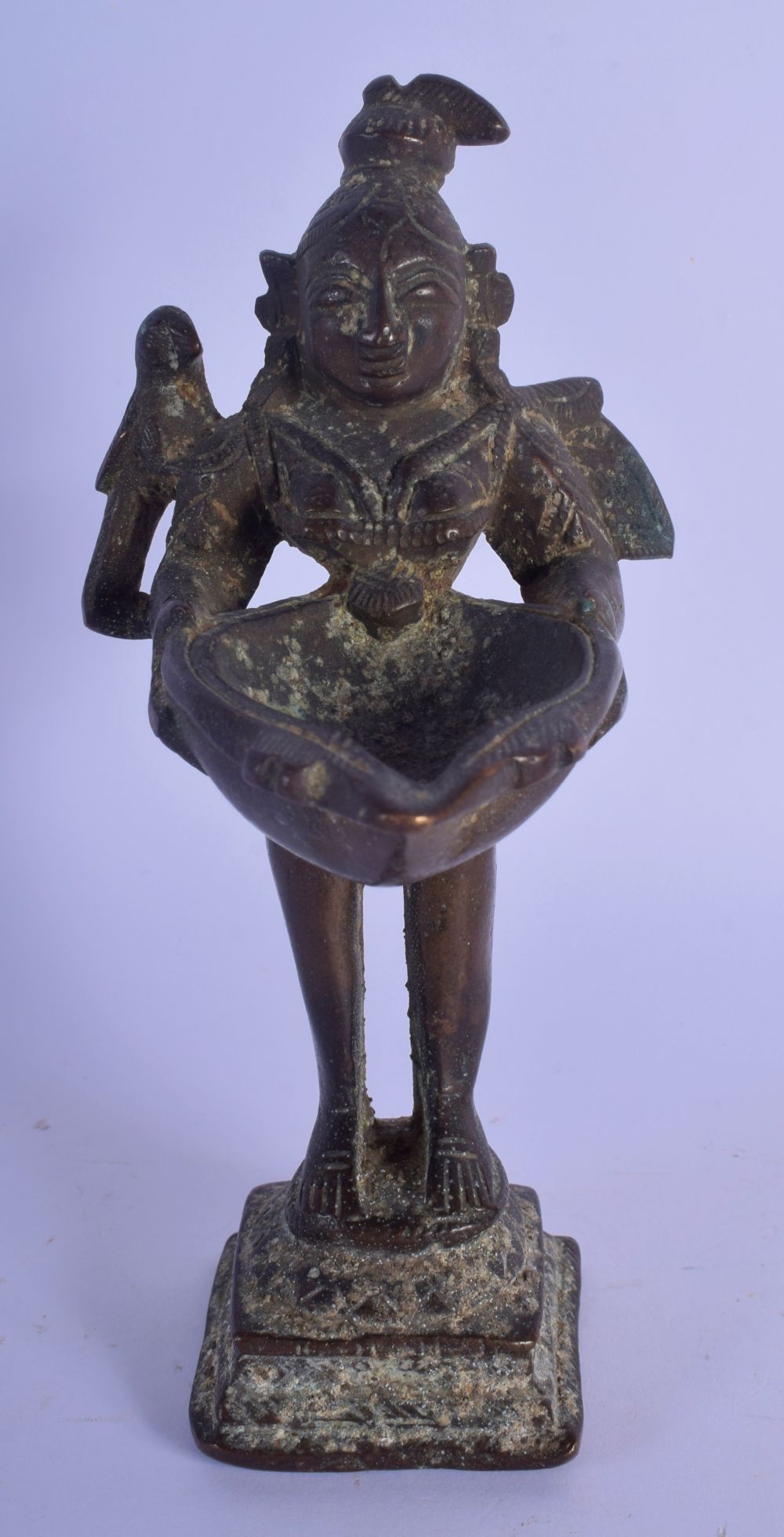 A 17TH/18TH CENTURY INDIAN BRONZE FIGURE OF A STANDING BUDDHIST DEITY modelled with a bird holding a