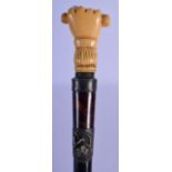 A GEORGE III IVORY AND TORTOISESHELL WALKING CANE with fist terminal. 90 cm long.