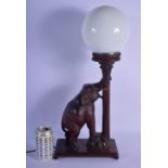 AN EARLY 20TH CENTURY INDIAN CARVED HARDWOOD ELEPHANT LAMP with horn tusks and opaque globe. 54 cm x