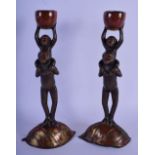A PAIR OF 19TH CENTURY JAPANESE MIXED METAL BRONZE CANDLESTICKS modelled as apes holding aloft nuts.