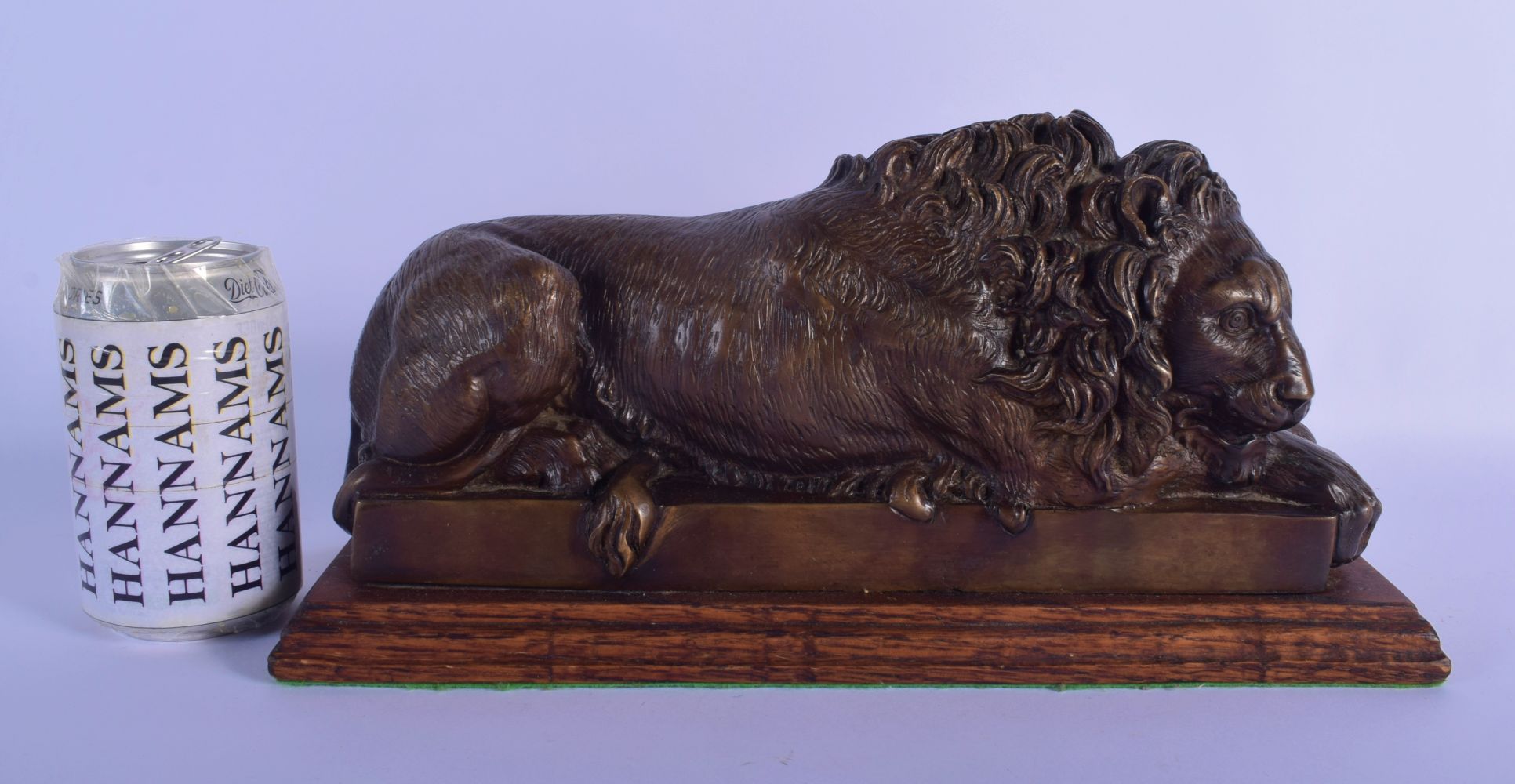 AN EARLY 20TH CENTURY EUROPEAN BRONZE FIGURE OF A SLEEPING LION After the Antiquity, modelled upon a