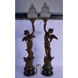 A LARGE PAIR OF ART NOUVEAU PATINATED SPELTER LAMPS modelled as winged maidens. 75 cm high inc shade