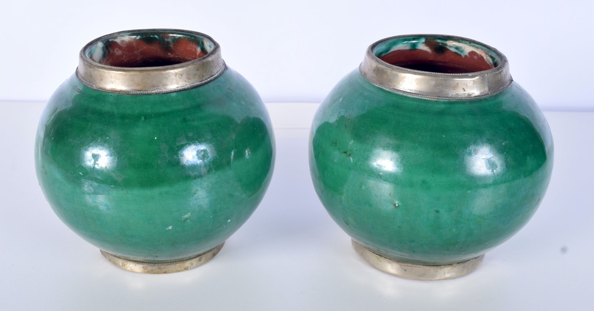 A pair of glazed terracotta jars with white metal mounts 13 x 13cm.