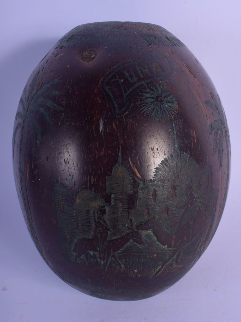 A 1920S SOUTH AMERICAN CARVED COCONUT BUGBEAR SHELL decorated with figures in various pursuits. 11 c