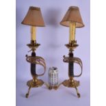 A RARE PAIR OF ANTIQUE MILITARY SABRE HANDLED CANDLESTICK STAMPS upon splayed legs. 48 cm high overa