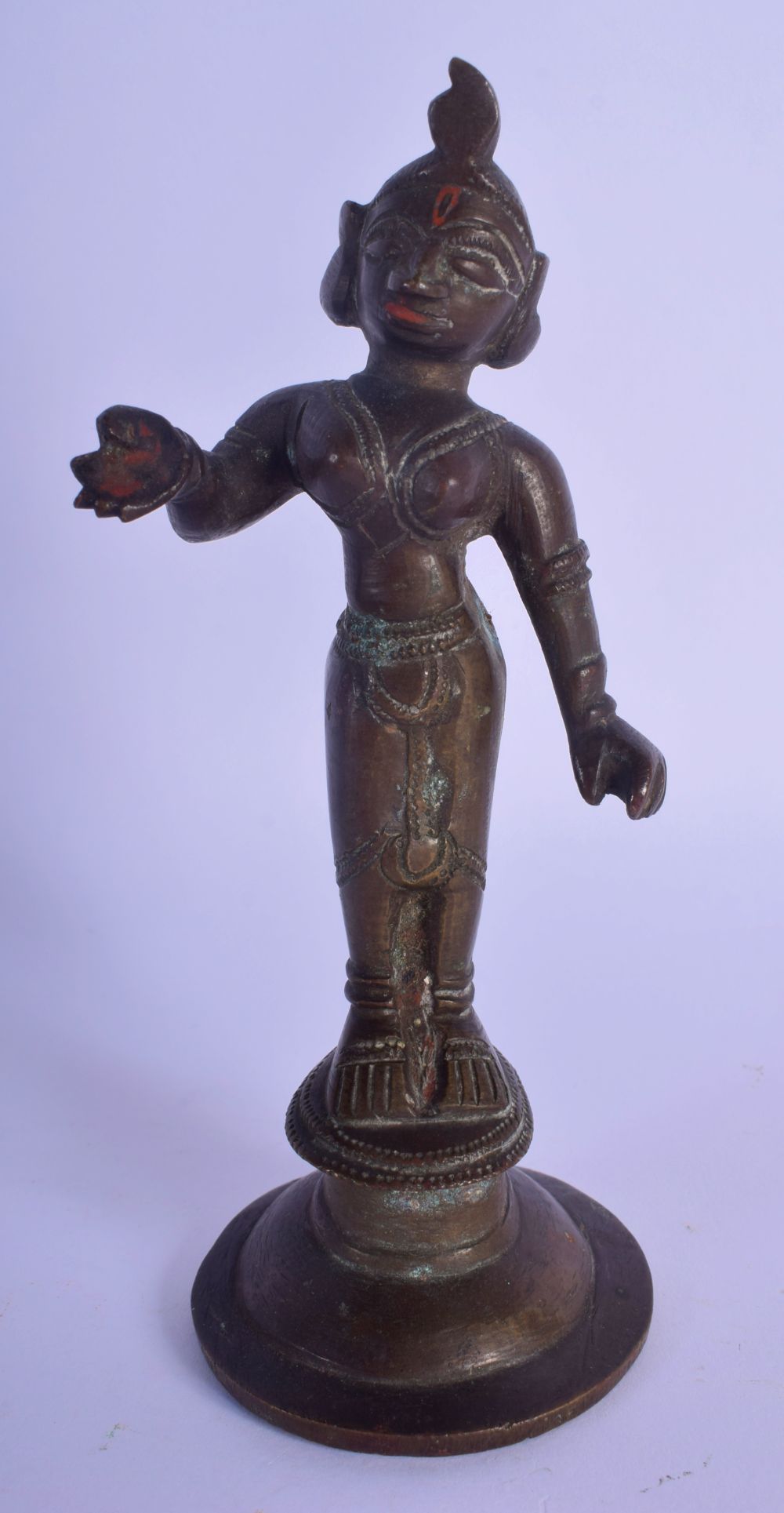 AN 18TH/19TH CENTURY INDIAN BRONZE FIGURE OF A BUDDHA modelled with one hand raised, with red paint