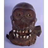 A RARE EARLY 20TH CENTURY AFRICAN TRIBAL ANIMAL SKIN MONKEY SKULL modelled with a bone within its mo