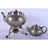 TWO 19TH CENTURY CONTINENTAL JAPANESE STYLE WHITE METAL TEAPOTS decorated with a scaley ground. Larg