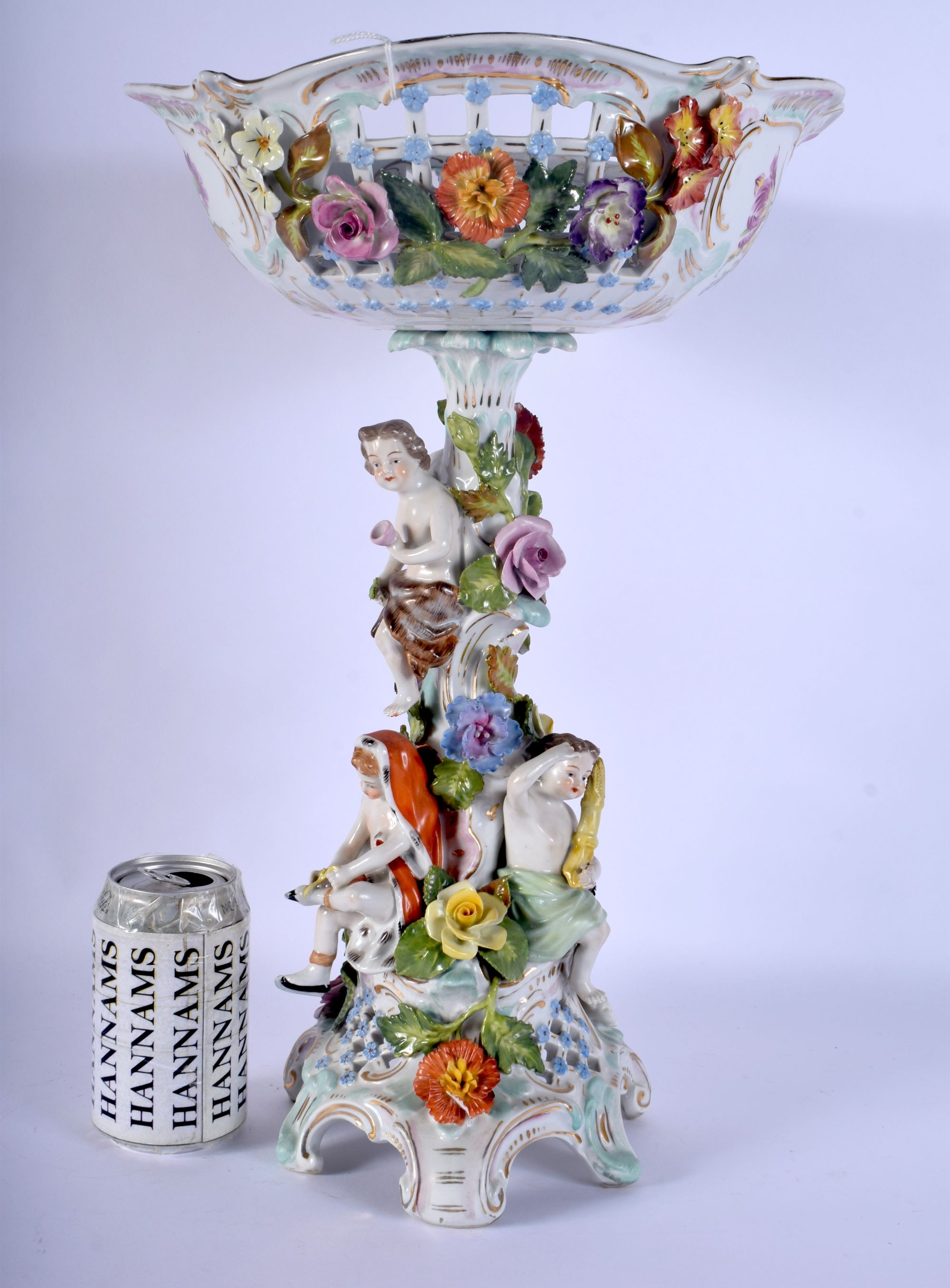 A LARGE ANTIQUE GERMAN PORCELAIN COMPORT modelled with figures under a floral bowl. 43 cm x 22 cm.