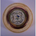 A GEORGE III GOLD MOUNTED IVORY BOX AND COVER painted with flowers. 5.5 cm diameter.