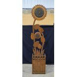 A large carved wood flower head clock and stick stand