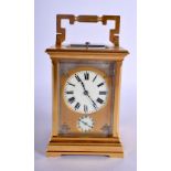 AN ANTIQUE REPEATING BRASS CARRIAGE CLOCK with silver overlaid dial. 18 cm high inc handle.