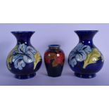 A PAIR OF MOORCROFT VASES and a William Moorcroft pomegranate vase. Largest 15 cm high. (3)