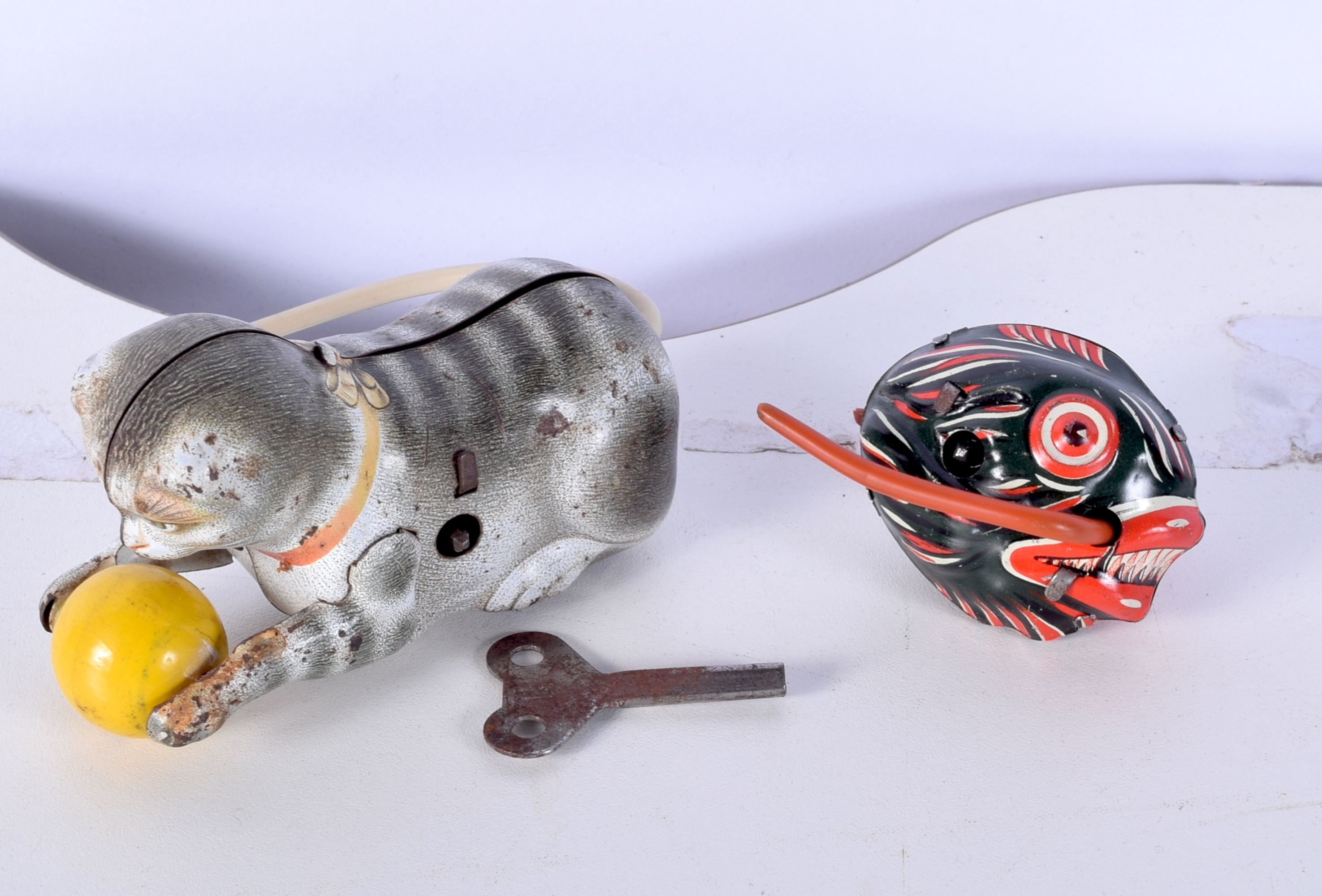 A small vintage wind up tin Piranha together with a wind up cat largest 11cm.