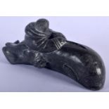 AN UNUSUAL NORTH AMERICAN INUIT CARVED STONE FIGURE OF AN ESKIMO modelled riding upon a dolphin. 18