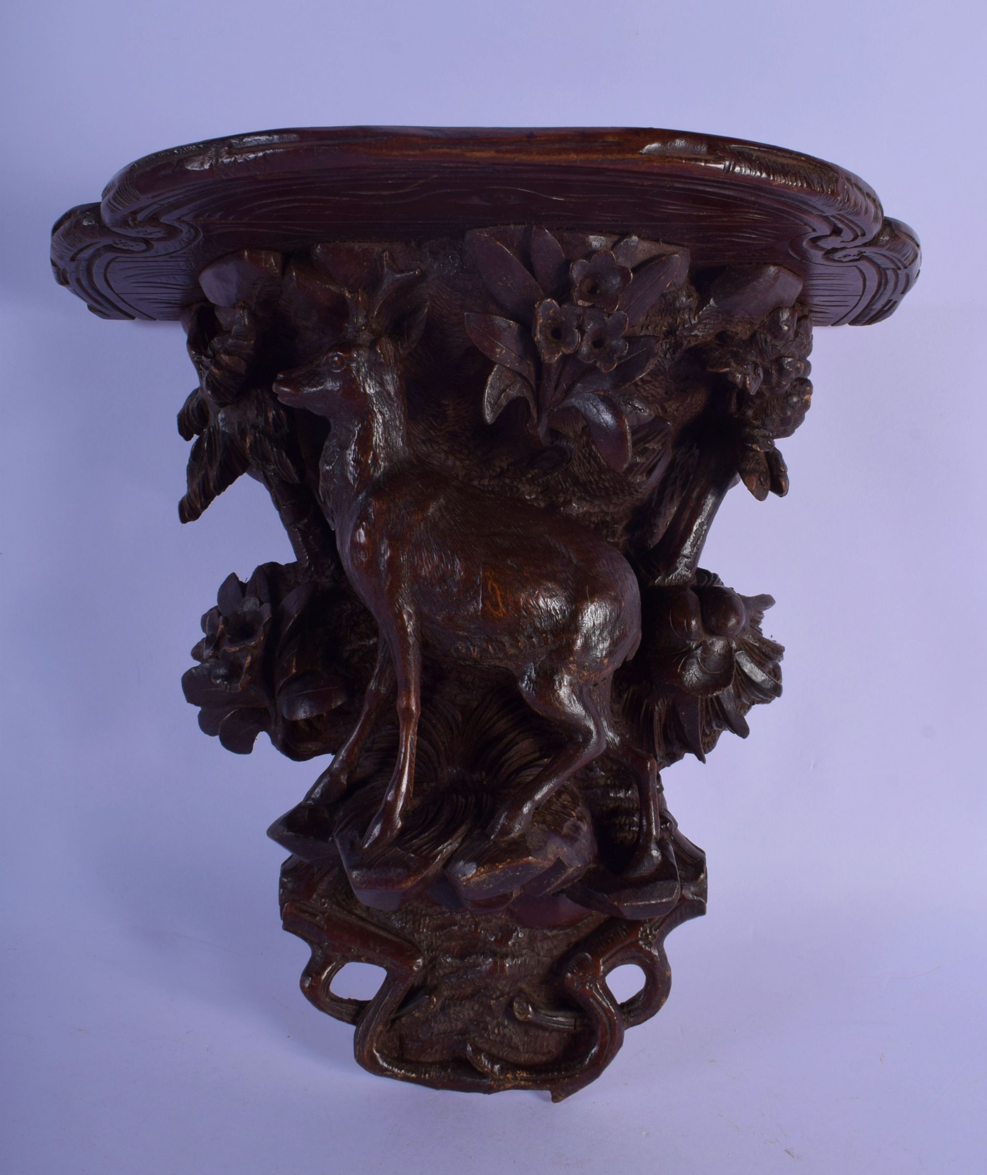 A 19TH CENTURY BAVARIAN BLACK FOREST WALL BRACKET modelled as a deer under foliage. 27 cm x 22 cm.