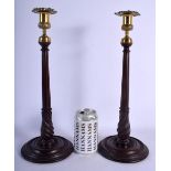 A PAIR OF EDWARDIAN MAHOGANY AND BRASS CANDLESTICKS. 39 cm high.