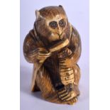 A 19TH CENTURY JAPANESE MEIJI PERIOD CARVED IVORY NETSUKE modelled as an ape pretending to be a coll