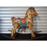 A vintage tin plate child's rocking horse 80 x 106 cm.