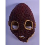 AN UNUSUAL JEWELLED AFRICAN TRIBAL MASK overlaid with nuts. 18 cm x 22 cm.