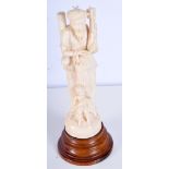 A 19TH CENTURY ANGLO INDIAN CARVED IVORY FIGURE OF A MUSICIAN modelled with a child. 23 cm high.