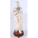 A 19TH CENTURY CHINESE CARVED IVORY FIGURE OF A STANDING WARRIOR modelled clutching his beard. 25 cm