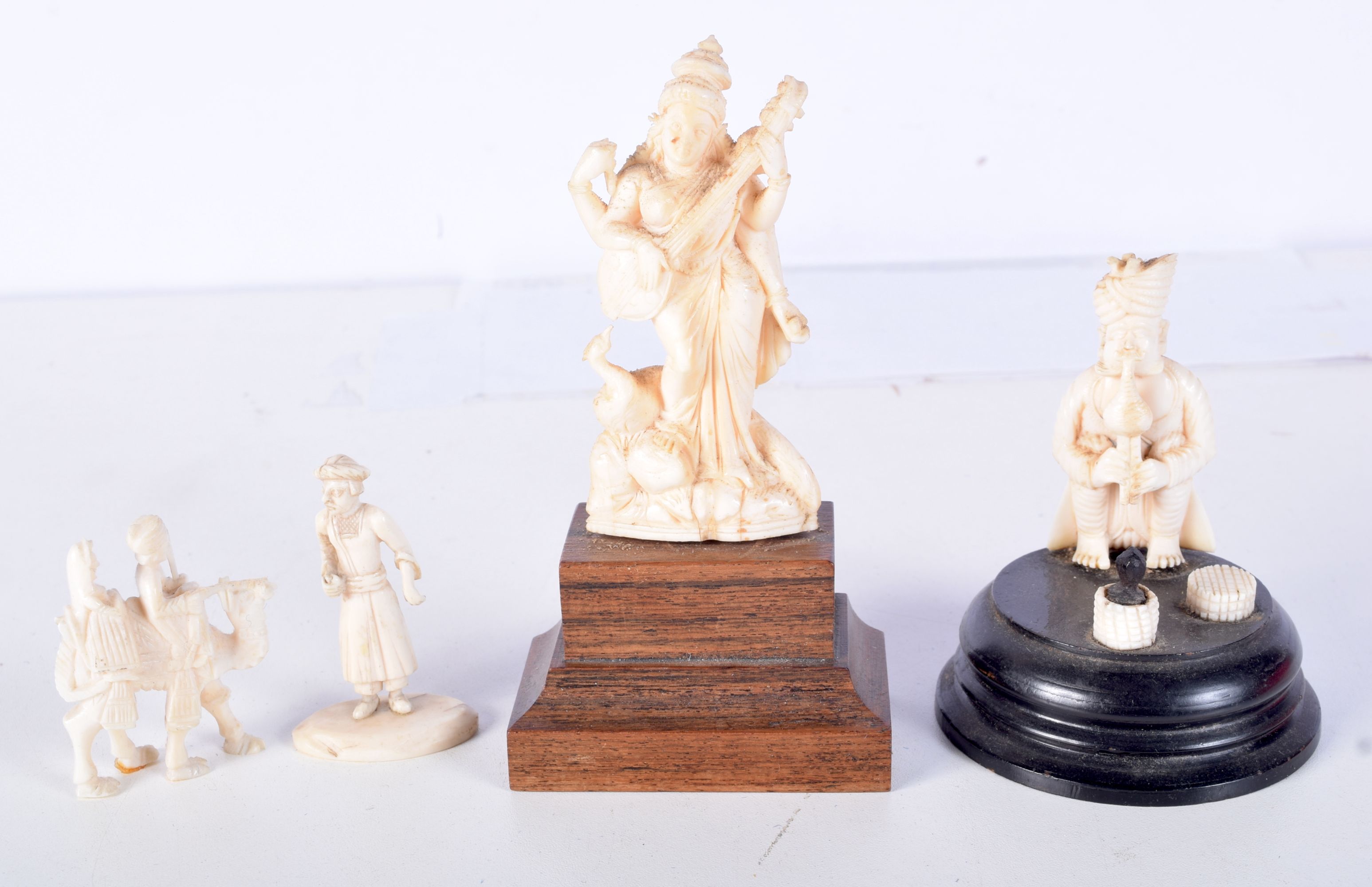 A 19TH CENTURY ANGLO INDIAN CARVED IVORY FIGURE OF A SNAKE CHARMER together with a musician and anot