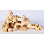 A 19TH CENTURY JAPANESE MEIJI PERIOD CARVED IVORY OKIMONO modelled as a child and father holding fru