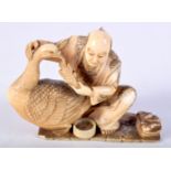 A 19TH CENTURY JAPANESE MEIJI PERIOD CARVED IVORY OKIMONO modelled as a male holding a bird. 8.5 cm