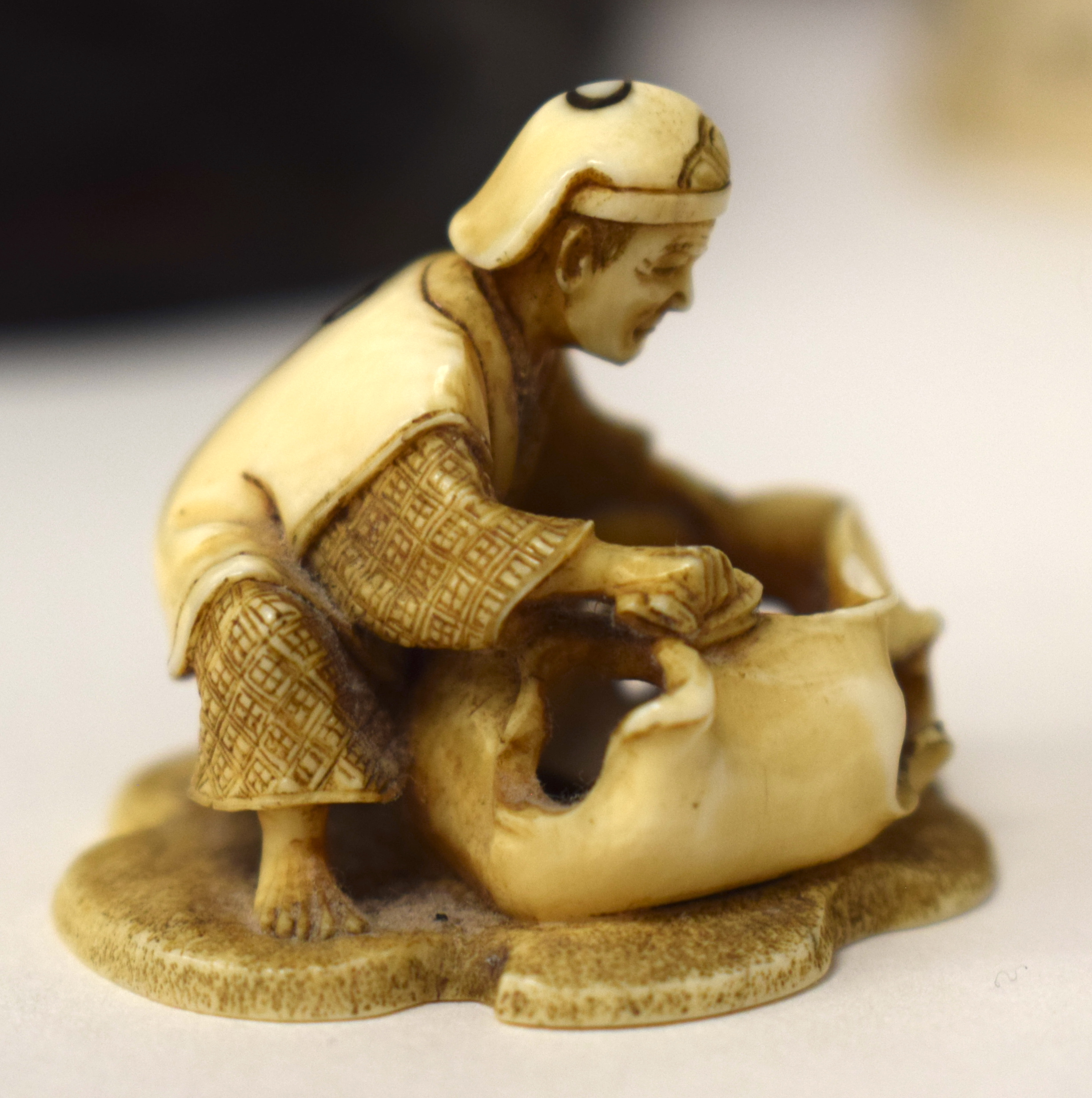 A 19TH CENTURY JAPANESE MEIJI PERIOD CARVED IVORY NETSUKE modelled as a male holding a sack. 3 cm x - Image 7 of 13