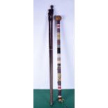 A pair of wooden walking canes carved with African figures for handles together with a tribal beaded