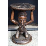 An African wooden tribal stool. 49 x 29 cm .