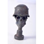 A BRASS PIPE TAMPER IN THE FORM OF A SKULL WEARING A MILITARY HELMET. 4.5cm x 2.6cm, weight 48g