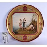 A LARGE EARLY 20TH CENTURY VIENNA PORCELAIN CHARGER painted with four figures within a landscape. 42