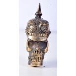 A BRASS VESTA CASE IN THE FORM OF A SKULL WEARING A PICKELHAUBE. 6.5cm x 3.7cm, weight 47g