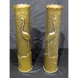 A pair of trench art repousse shell case vases decorated with storks, signed ~Hamel~. 38cm (2).