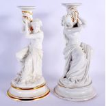 A PAIR OF 19TH CENTURY EUROPEAN WHITE GLAZED PORCELAIN CANDLESTICKS painted with figures. 26 cm high