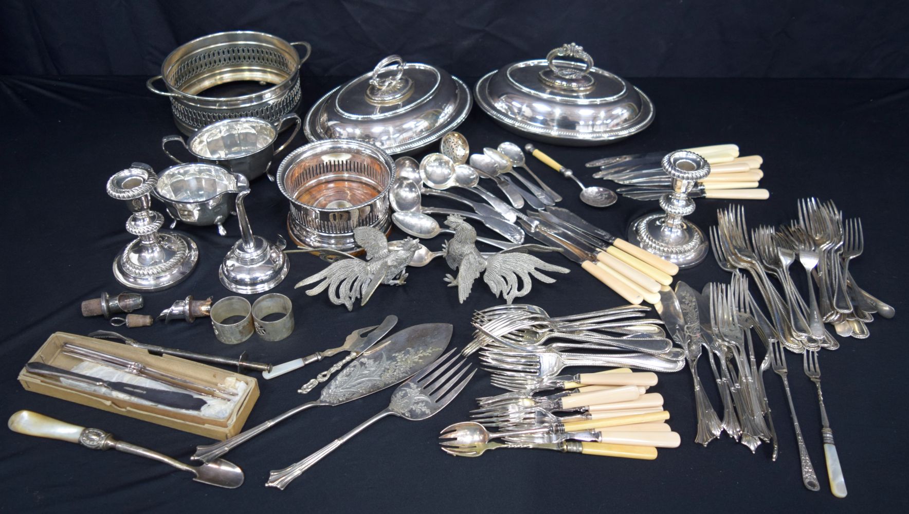 A large collection of silver plated items serving dishes, flatware, wine holders, candle sticks etc