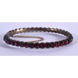 AN ANTIQUE BOHEMIAN GARNET ENCRUSTED BANGLE. 5.6cm x 4.5cm internal dimensions, weight 16.4g