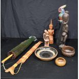 A miscellaneous collection of wooden figures, bowls, a stone figure of two people embracing, a paras